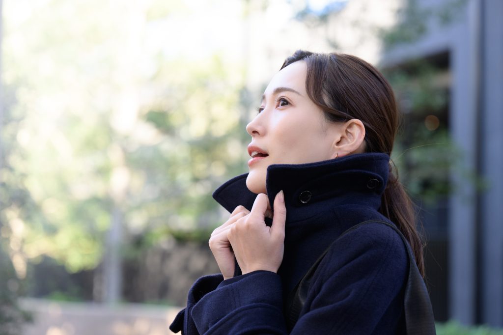 東京都 港区 麻布十番 ネクスト・アイズ|寒くてコートの襟を立てる女性